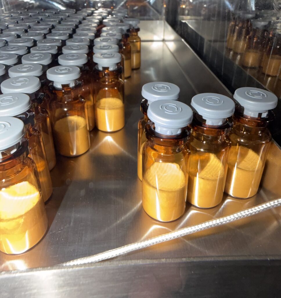 Amber glass vials with grey caps on a production line